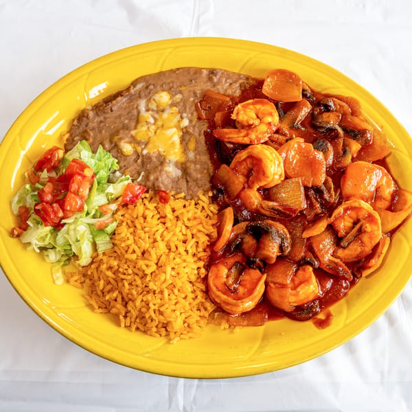 Shrimp with mushrooms and vegetables in red sauce, served with rice, refried beans, and salad.